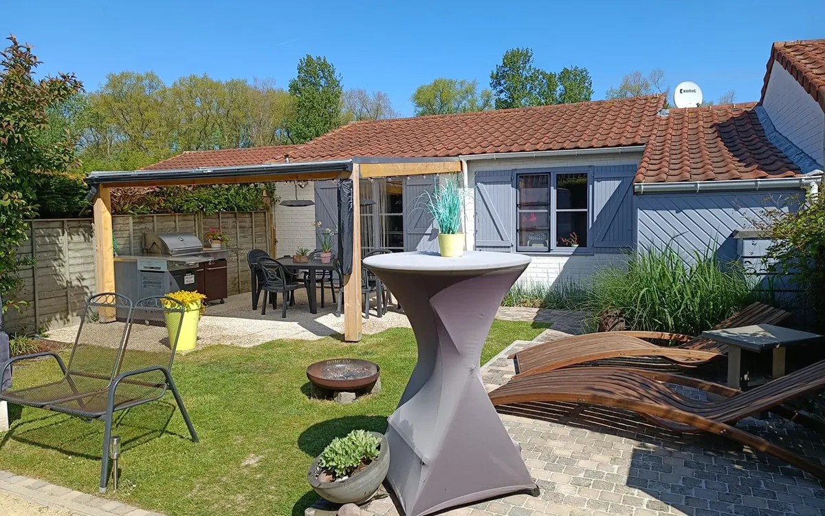 Jardin de la maison de vacances avec terrasse couverte, barbecue et transats