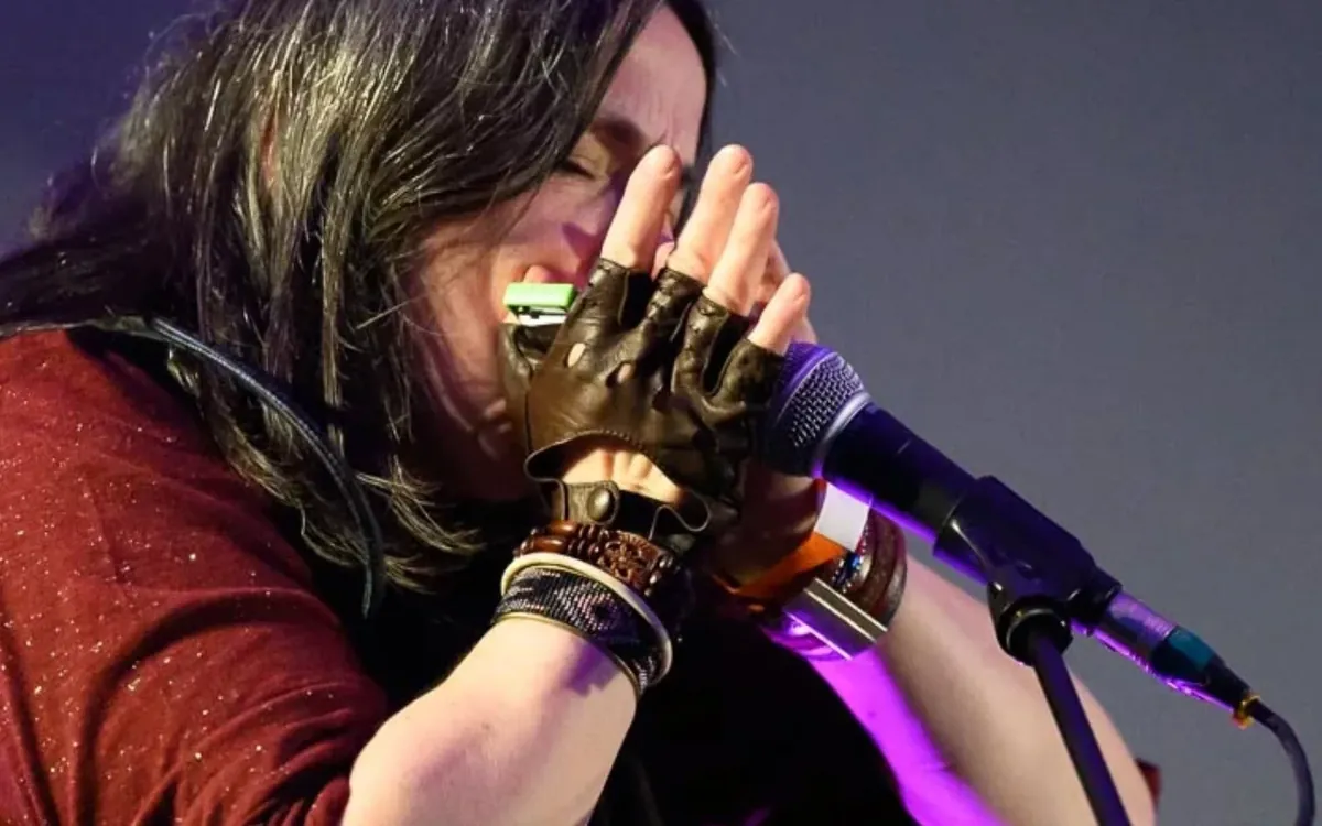 Geneviève Dartevelle jouant de l'harmonica sur scène